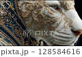 A majestic white tiger adorned in luxurious, gold-embroidered regal attire, featuring intricate baroque patterns, gazes thoughtfully, capturing elegance and power in a royal portrait style. 128584616