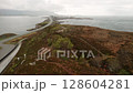 Stretch of Atlantic ocean road gracefully winding across islands connecting over Norwegian waters. Harmonious blend of human ingenuity and raw nature 128604281