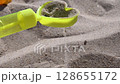 Sand grains pouring through sand sifter. Yellow plastic toy sand sifter in shape of heart. Games with clean white beach sand scattering from sieve. Summer leisure kid fun #beach #asmr #relax 128655172