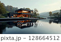 Modern house on a lake with a forest in the background. concept of ecological house keeping and luxury real estate, nature retreats, sustainable living, and tranquil, harmonious lifestyle. 128664512