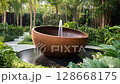 rustic garden fountain bowl in lush tropical landscaping 128668175