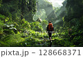 man hiking through lush jungle path sunlight filtering through rock 128668371