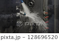 Close-up of CNC machine during high-speed metal processing, with visible coolant spray and cutting action. Concept of industrial precision, automation, and advanced manufacturing. 128696520