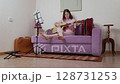 Woman depicted playing acoustic guitar, showcasing refined technique that attests to proficiency in art of music. She engaged in refinement of her musical abilities within confines of personal studio 128731253