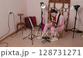 Young woman guitarist energetically playing acoustic classical guitar in strumming style in home studio, practicing and engaged in music education. Female musician in casual clothes. Handheld shot 128731271