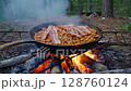 Campfire cooking: sizzling bacon and beans in outdoor wilderness setting 128760124