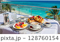 Luxurious breakfast by the ocean: sunny morning with fruit and waffles on a terrace 128760154