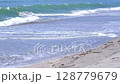 A video showing the scenery of the beach's edge, where the waves are constantly lapping and retreating, and the viewer relaxing on the beach. 128779679