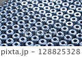 Close-up view of precision machined metal components produced by CNC. Industrial setting showcasing uniformity and accuracy. Concept of mass production and metal engineering 128825328