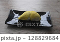 hand holding durian king of tropical fruit in black plate on table and tearing for eat 128829684