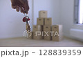 A hand grasps keys against a backdrop of containers. 128839359
