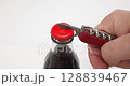 4K - Opening a bottle of lemonade with a bottle opener 128839467