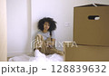 Relaxed Young Woman Amid Moving Boxes in New Bright Apartment. 128839632