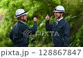 Veteran and young workers fist bumping and putting their arms around each other's shoulders 128867847