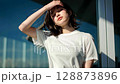 夏天，一位女士因為陽光太刺眼而雙手抱頭 128873896