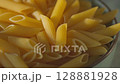 Uncooked Penne Pasta in Bowl Close-Up Panning Camera Shot 128881928