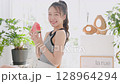 Summer lifestyle of a young woman eating watermelon in her room 128964294