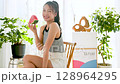 Summer lifestyle of a young woman eating watermelon in her room 128964295