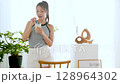 Summer refreshing young woman drinking lemonade in room 128964302