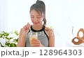 Summer refreshing young woman drinking lemonade in room 128964303