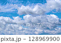 Dynamic clouds moving on a bright blue sky. 128969900