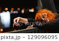 Portrait of a beautiful fiery red-haired woman on a city street at night. 129096095