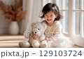 Innocent smiling childhood: Girl playing with teddy bear 129103724