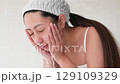 一位年輕的亞洲女子正在洗臉。 129109329
