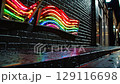 Neon rainbow light installation on wet brick wall radiates vibrant urban energy creativity optimism nightlife and freedom inspiring uniqueness and diversity 129116698