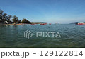 A serene coastal scene with boats docked on calm waters by a beach 129122814