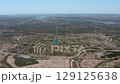 Multiple wind turbines are gracefully rotating, generating clean energy amidst an agricultural landscape, with alqueva lake visible in the distance under a clear blue sky 129125638