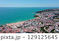 Aerial view of albufeira coastal city in algarve region of portugal, showcasing turquoise waters of atlantic ocean meeting sandy beaches and red roofed buildings of the town. Praia dos pescadores. 129125645