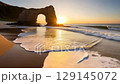 Sea arch and sandy beach at sunrise 129145072
