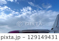 Airplane Wing Against Beautiful Blue Sky with Serene Clouds 129149431