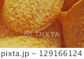 Golden Crispy Potato Chips Spinning in Bowl Overhead Macro Shot 129166124