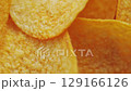 Golden Crispy Potato Chips Spinning in Bowl Overhead Macro Shot 129166126