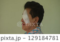 elder woman covering protection on left eye smiling after cataract surgery in cream background 129184781