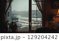 View from a cozy indoor window on a rainy winter day with warm lighting. 129204242