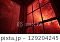 Dramatic red light streaming through a rain-splattered window, mysterious atmosphere. 129204245