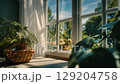 Serene indoor scene with green plants, natural light, and a sunny window view. 129204758