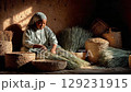 Young girl engaged in traditional weaving with natural materials, surrounded by handmade baskets, showcasing craftsmanship and cultural heritage in a warm, rustic environment 129231915