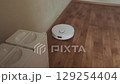 Effortless cleaning automated floor care robot glides across room collecting dust and debris for a spotless home 129254404