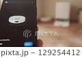 Smartphone screen displays app for controlling robot vacuum using modern technology for efficient home cleaning and convenience 129254412