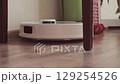 Robot vacuum is cleaning the room starting with dry vacuuming and then switching to mopping for a complete floor cleanup. 129254526
