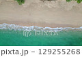 Aerial drone view (top down) to sea waves and white sand. Turquoise blue water, tropical theme. Concept of relaxation in pure nature. 129255268