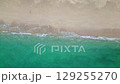 Aerial drone view (top down) to sea waves and white sand. Turquoise blue water, tropical theme. Concept of relaxation in pure nature. 129255270