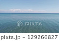 Aerial view of crystal-clear turquoise water at Hachigasaki Beach in Noto, Japan. The calm sea stretches into a distant horizon under a bright summer sky. Peaceful and minimalist ocean scene. 129266827
