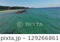 FPV drone flies low and fast alongside a breakwater at Goshikigahama Beach in Noto, Japan. Clear emerald waters, wave patterns, and shoreline vegetation create a vibrant and immersive coastal flight. 129266861