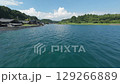 FPV drone glides along a traditional coastal village in Noto. The calm bay forested hills and sea facing wooden houses highlight the regions charm and connection to nature 129266889