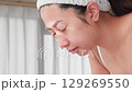 一位年輕的亞洲女子正在洗臉。 129269550
